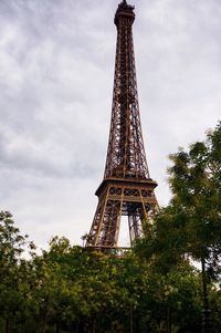 Low angle view of eiffel tower and trees against sky