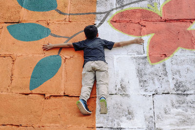 High angle view of boy lying on patterned footpath