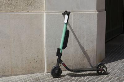 Bicycle on footpath against wall