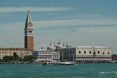 View of building by canal against sky