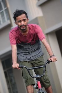 Portrait of young man standing on bicycle