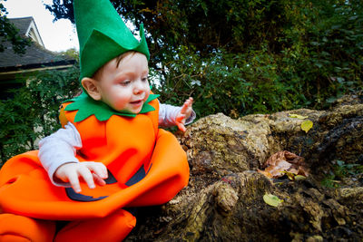 Boy in halloween costume by tree roots