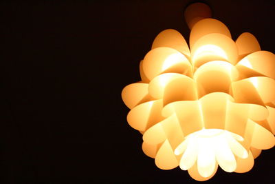 Close-up of illuminated light bulb against black background