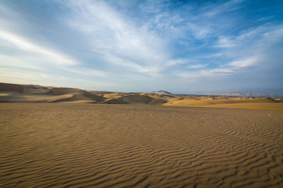 Rippled sand in desert against sky