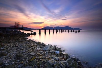 Scenic view of bay against sky at sunset