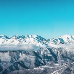 Scenic view of snowcapped mountains against clear blue sky