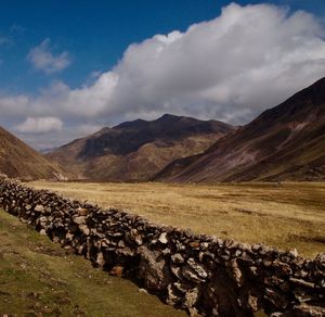 Scenic view of land and mountains against sky