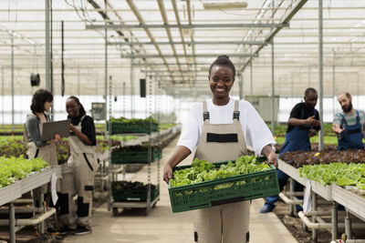 Portrait of young man standing in greenhouse