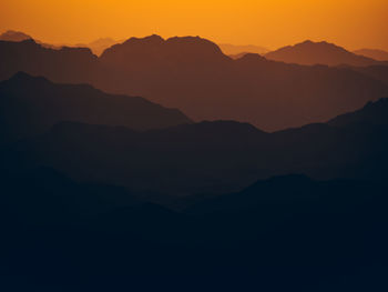 Scenic view of silhouette mountains against sky during sunset