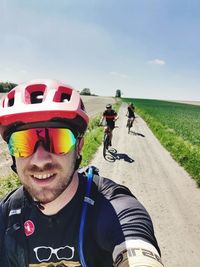 Portrait of man with arms raised against sky