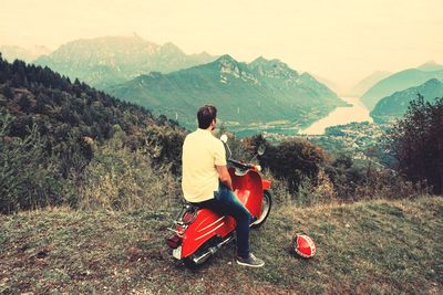 Rear view of man sitting on mountain road