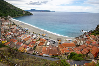 High angle view of townscape by sea against sky