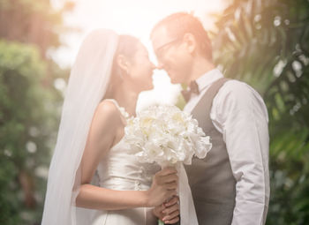 Loving wedding couple standing at backyard