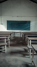 Empty chairs and table in abandoned building