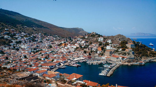 High angle view of townscape by sea against clear sky