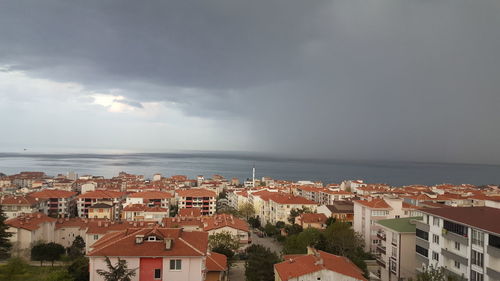 High angle view of townscape by sea against sky