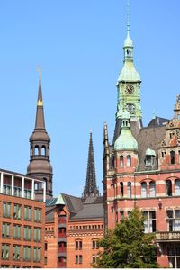 Low angle view of buildings against clear blue sky