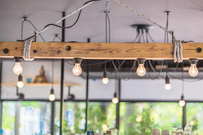 Low angle view of illuminated light bulbs hanging from ceiling