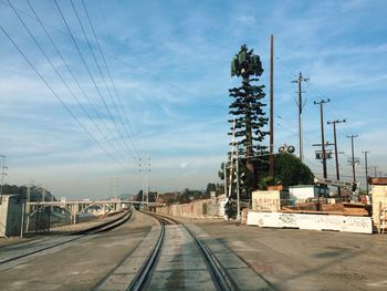 Railroad tracks against cloudy sky