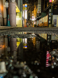 Reflection of building in puddle on street