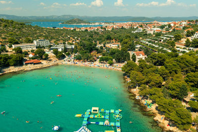 High angle view of townscape by sea against sky