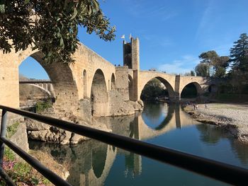 Arch bridge over river against sky