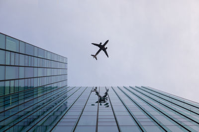 Low angle view of airplane flying against sky