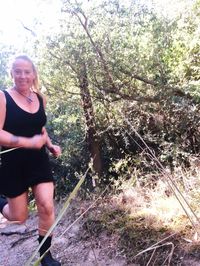 Woman standing by tree in forest