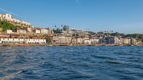 View of townscape by sea against clear sky
