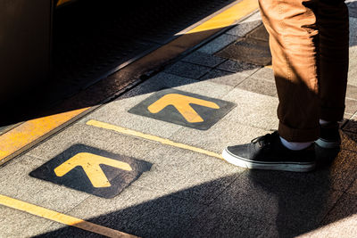 Low section of man standing on road
