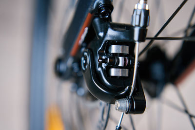 Part of the bicycle's braking system. grey metal brake disc and brake pads on road bike, close up.