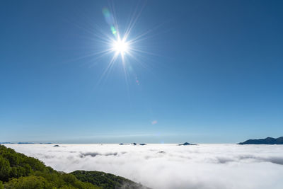 Scenic view of mountains against blue sky on sunny day