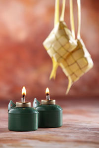 Close-up of decoration and illuminated oil lamp on table