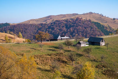 Houses on field by mountains against sky