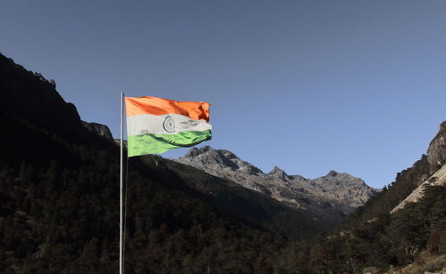 Low angle view of flag on mountain against clear sky