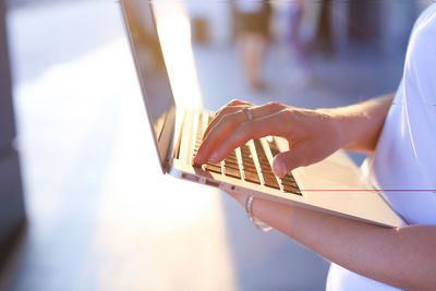 Midsection of woman using laptop