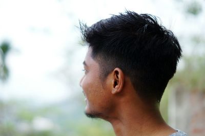 Close-up portrait of young man looking away outdoors
