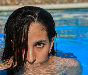 Close-up portrait of young woman in swimming pool