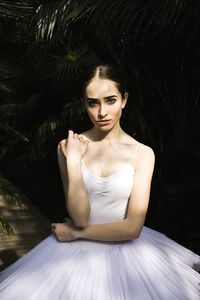 Portrait of a young woman sitting outdoors