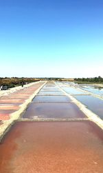 Surface level of road against clear blue sky