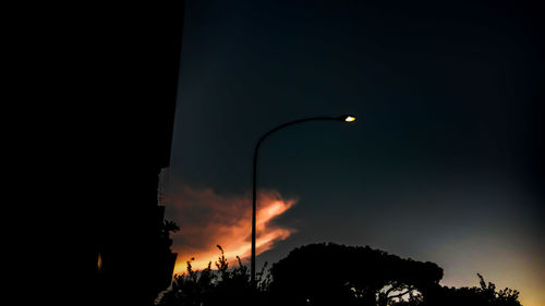 High section of silhouette trees against scenic sky