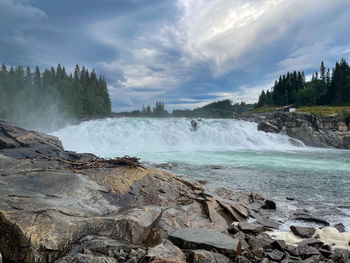 Scenic view of waterfall against sky