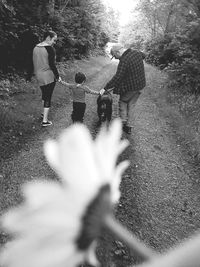 Rear view of people walking on plants