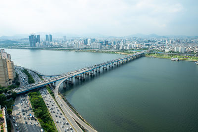 High angle view of bridge over river by buildings in city