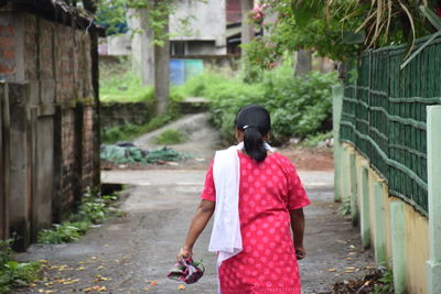 Rear view of woman walking on street in city