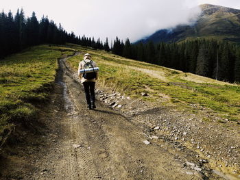 Rear view of man riding motorcycle on road