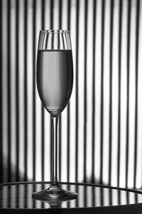 Close-up of champagne glass on table with stripes