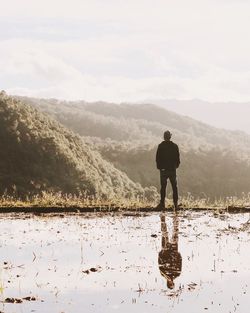 Man standing on landscape against sky