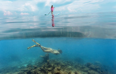 Young women have a fun in ocean, underwater view