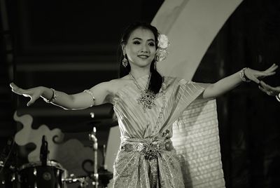 Portrait of smiling young woman at music concert